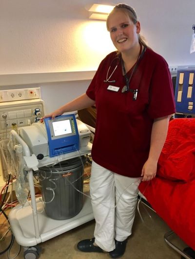 Unsere Kollegin aus der Peritonealdialyse neben einem medizinischem Gerät
